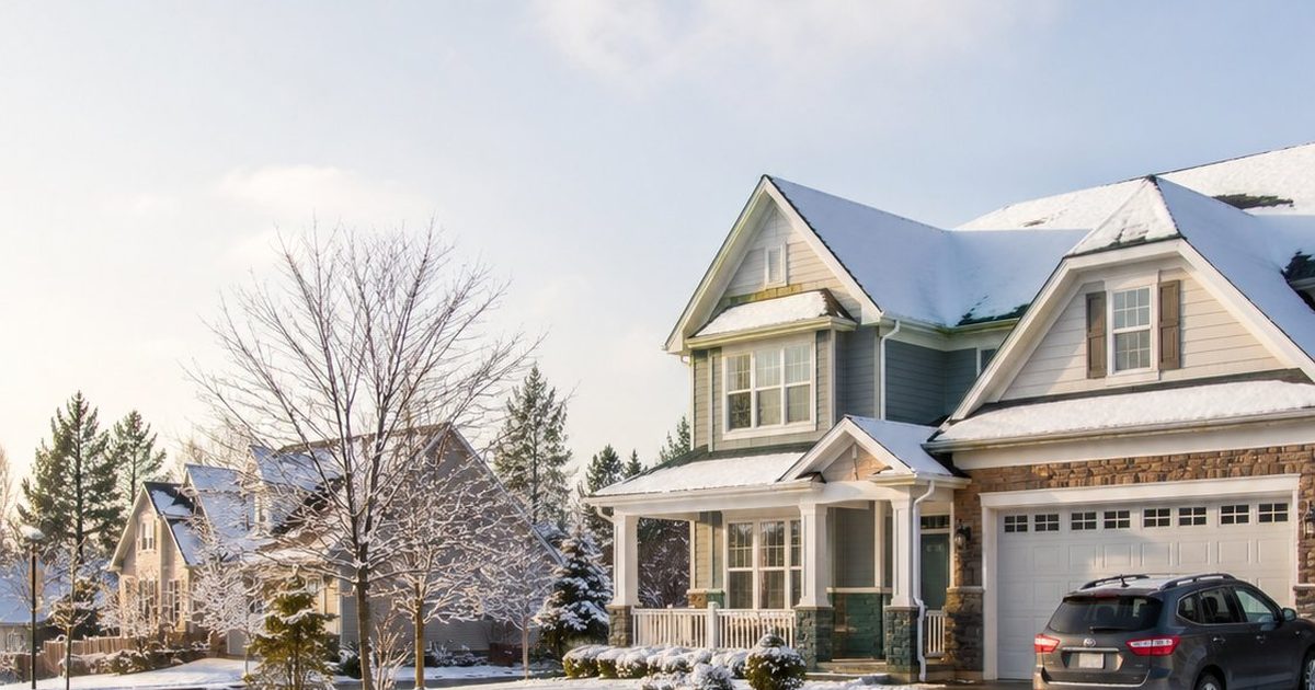 Snow-covered suburban home in winter, replacement cost versus actual cash value